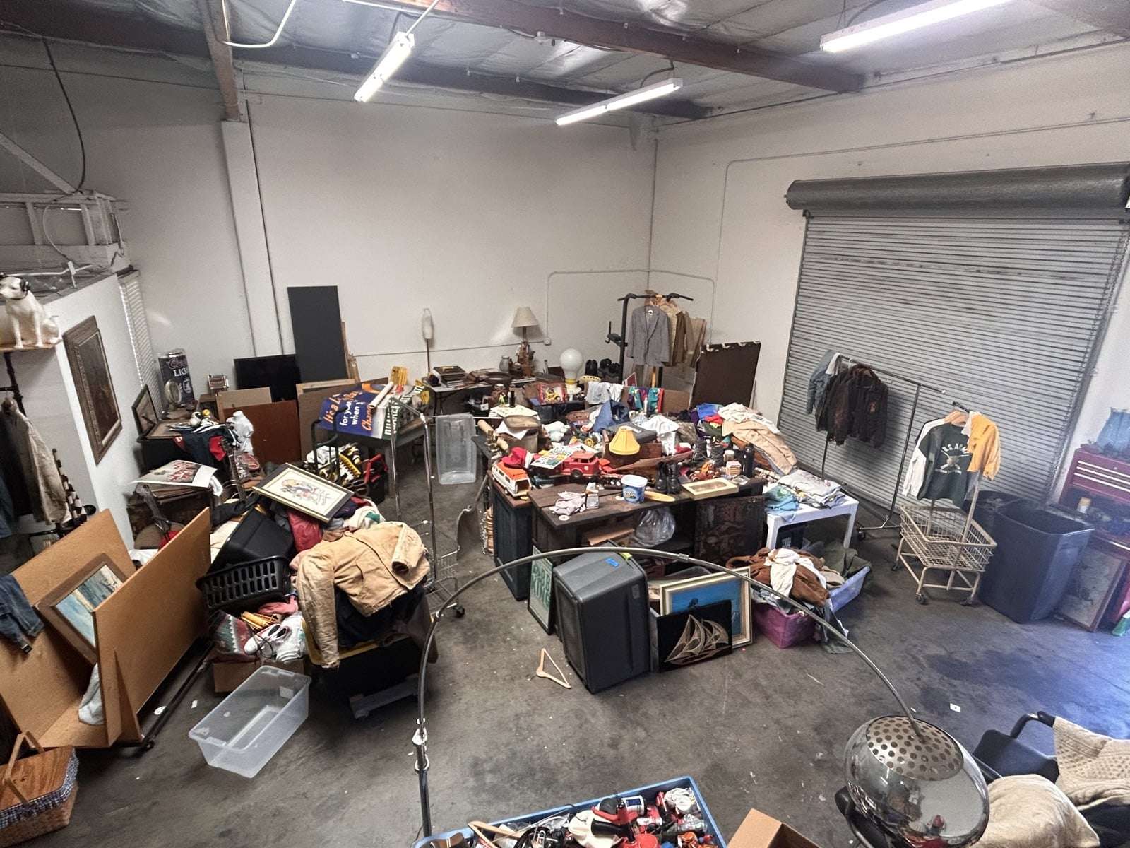 The warehouse floor covered in furniture, art, and estate finds being sorted