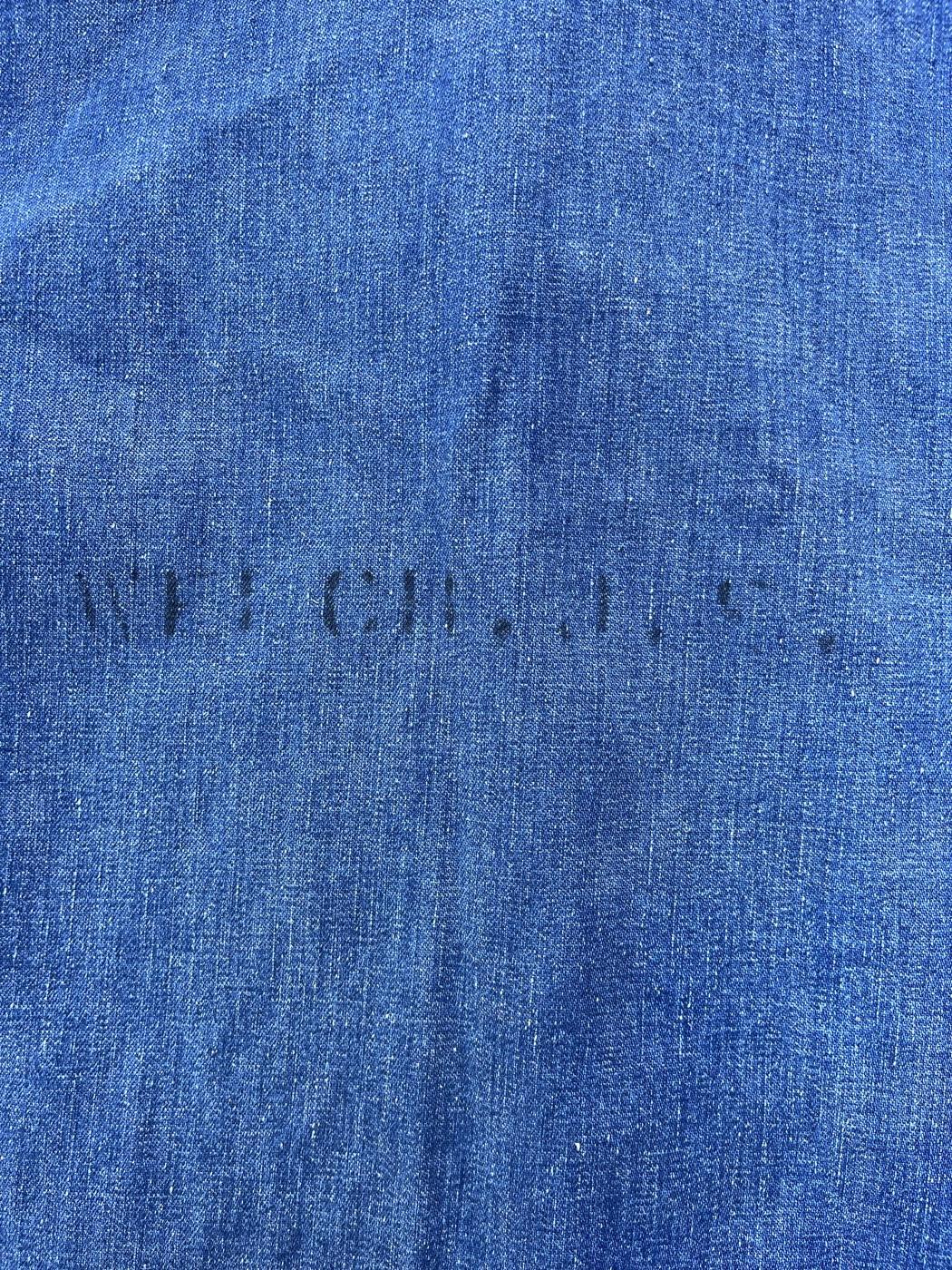 Faded name stencil across the back of a WWII US Navy denim deck jacket