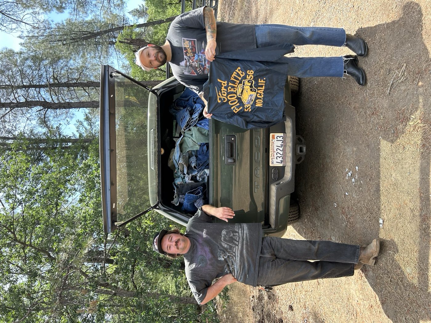 Two California Vintage Buyers staff behind a truck bed loaded with vintage denim from a buying trip