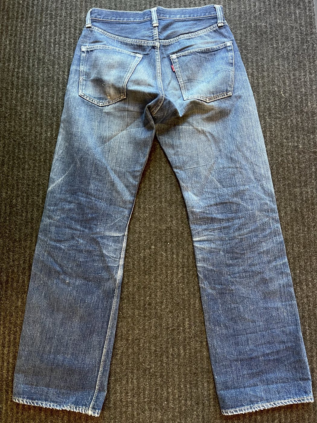 Close detail of 1940s Levi's 501XX denim showing the red tab, back pocket stitching, and rivet