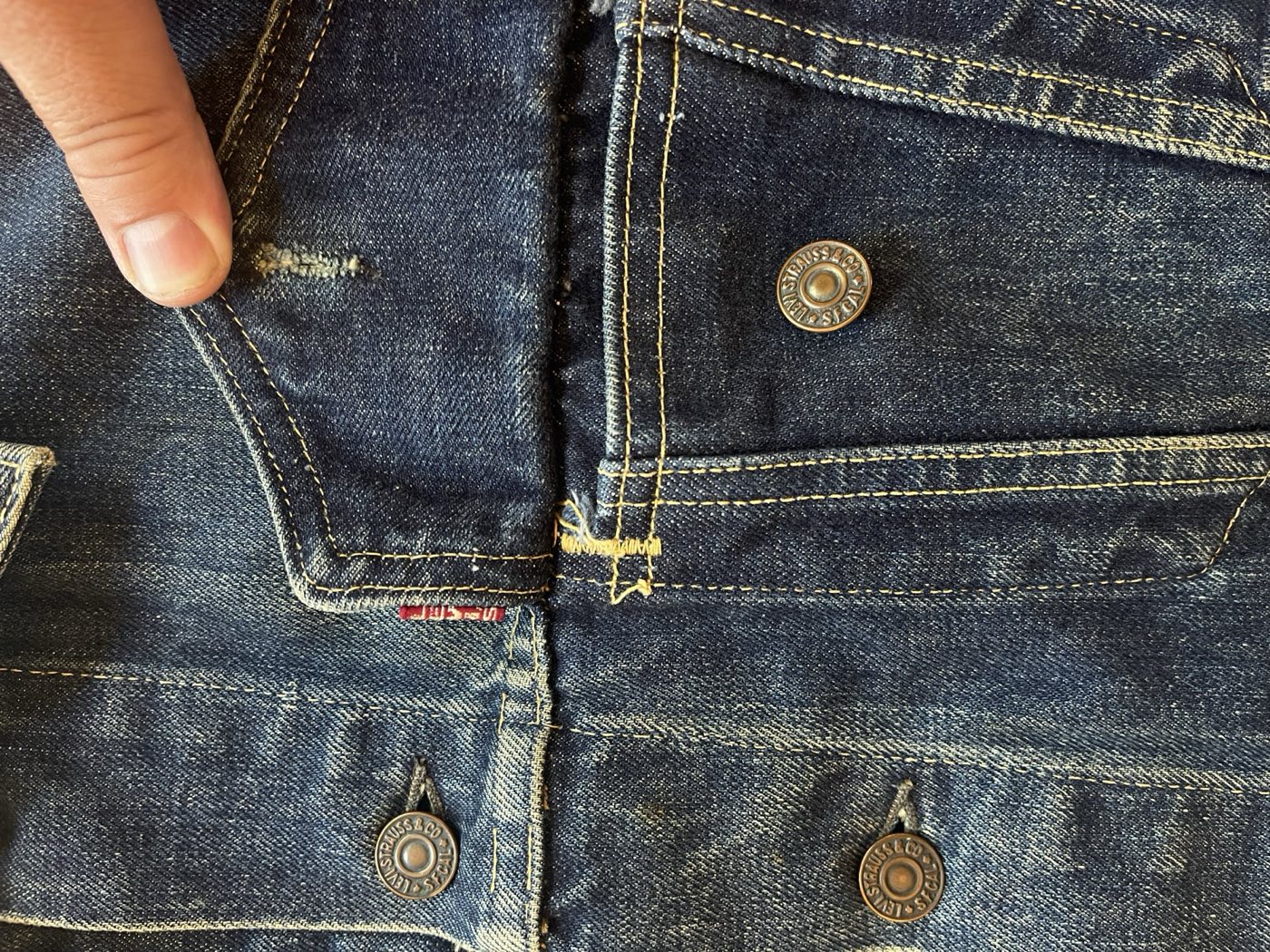 Close up of the red tab, chest pocket seam, and stamped Levi Strauss and Co buttons on a vintage Type 3 trucker jacket